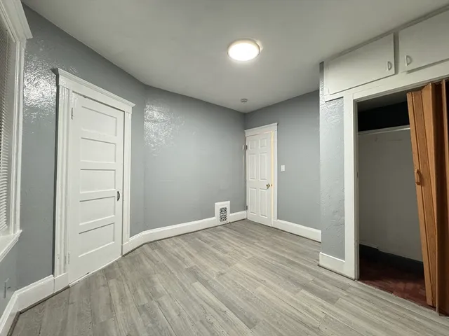 an empty room with wooden floor and closet