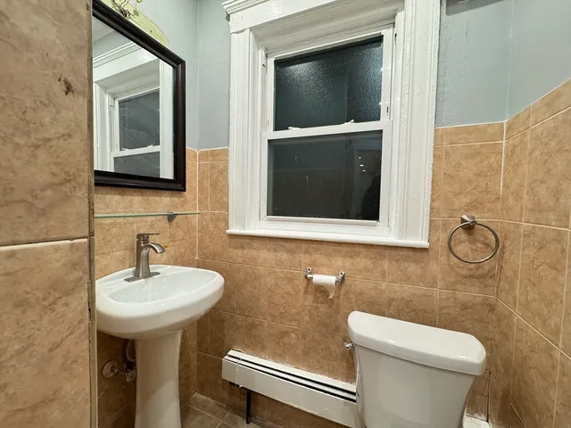 a bathroom with a toilet sink and mirror