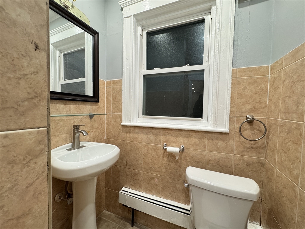10 Faxon Road, Unit 1 Quincy, MA 02171 - Photo 9 of 11 a bathroom with a toilet sink and mirror