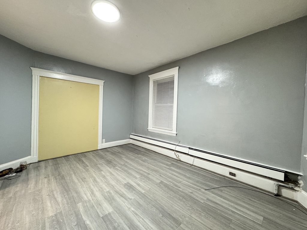 10 Faxon Road, Unit 1 Quincy, MA 02171 - Photo 10 of 11 an empty room with wooden floor and windows