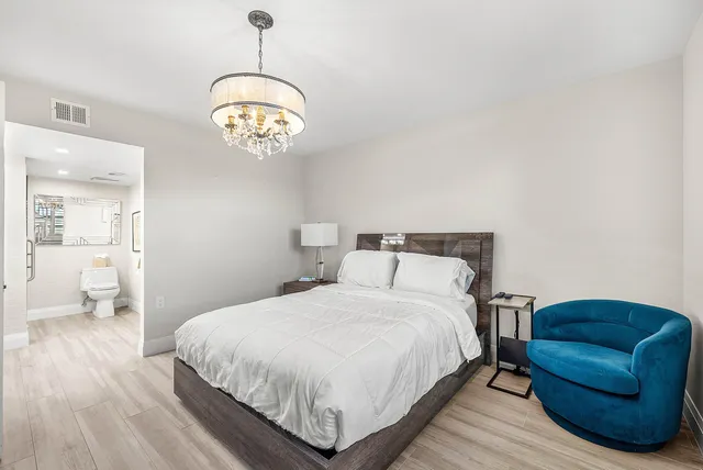 a bedroom with a bed and chandelier