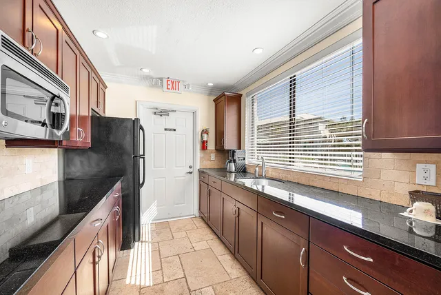 a kitchen with stainless steel appliances granite countertop a sink and a stove