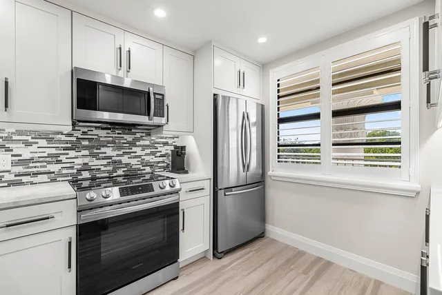 a kitchen with stainless steel appliances a stove microwave and refrigerator