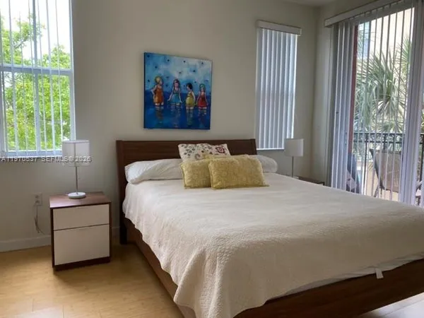 a bedroom with a bed and a painting on the wall
