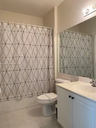 a bathroom with a granite countertop toilet and a sink
