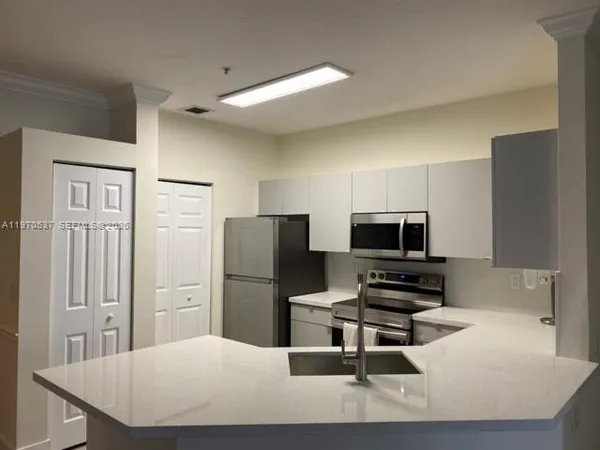 a kitchen with stainless steel appliances a refrigerator and a stove top oven