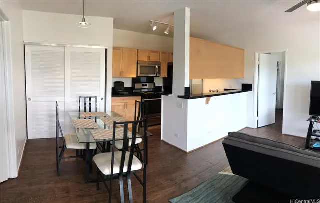 a kitchen with a dining table chairs and refrigerator