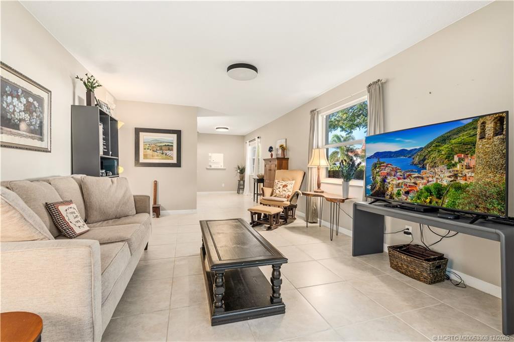 2600 Southeast Ocean Boulevard, Unit F7 Stuart, FL 34996 - Photo 12 of 54 a living room with furniture a flat screen tv and a floor to ceiling window