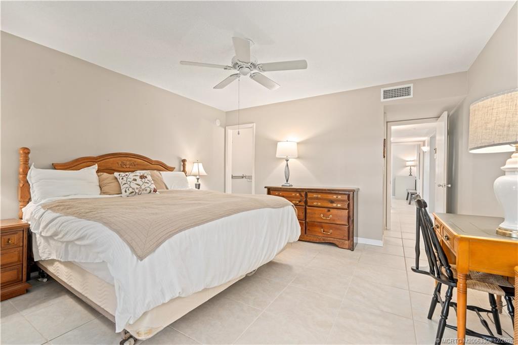 2600 Southeast Ocean Boulevard, Unit F7 Stuart, FL 34996 - Photo 21 of 54 a bedroom with a bed and a chandelier