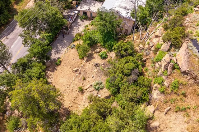 an aerial view of residential houses with outdoor space and trees