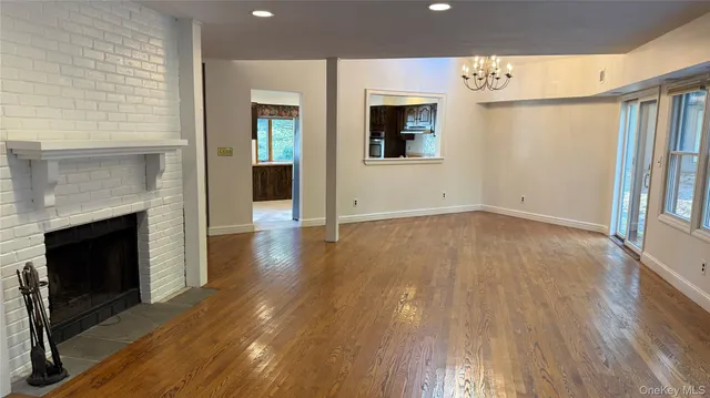 a view of a livingroom with wooden floor and a fireplace