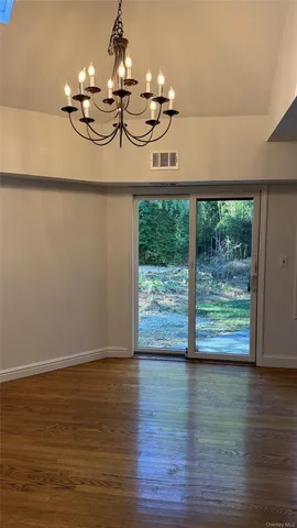 a view of a room with wooden floor fan and window