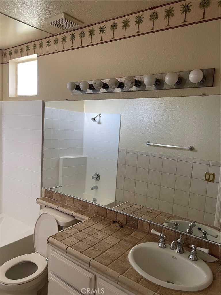 9279 Middlefield Drive Riverside, CA 92508 - Photo 12 of 26 a bathroom with a granite countertop sink a toilet and mirror