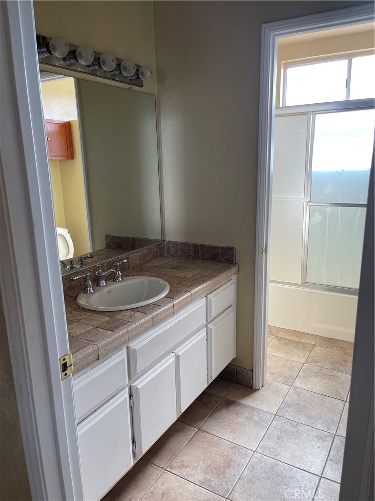9279 Middlefield Drive Riverside, CA 92508 - Photo 14 of 26 a bathroom with a granite countertop sink and a mirror
