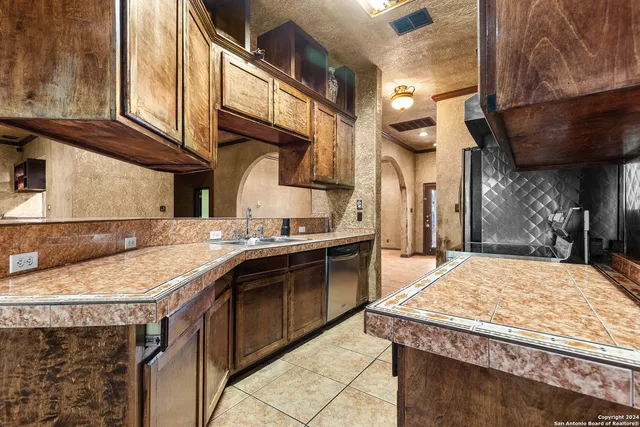 a large kitchen with stainless steel appliances granite countertop a stove and a refrigerator