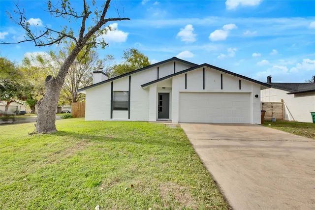 a view of a white house with a large tree and a yard