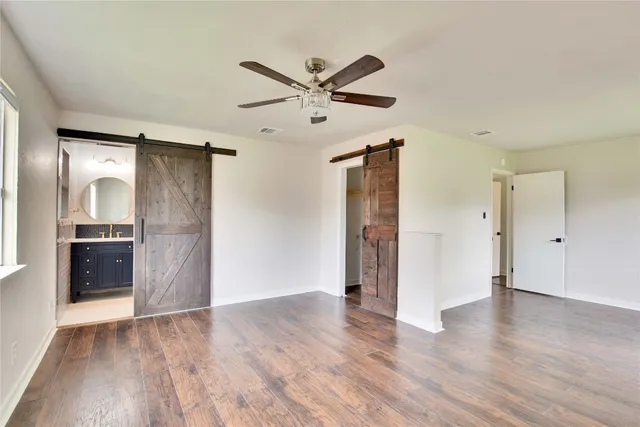a view of a big room with wooden floor and a kitchen