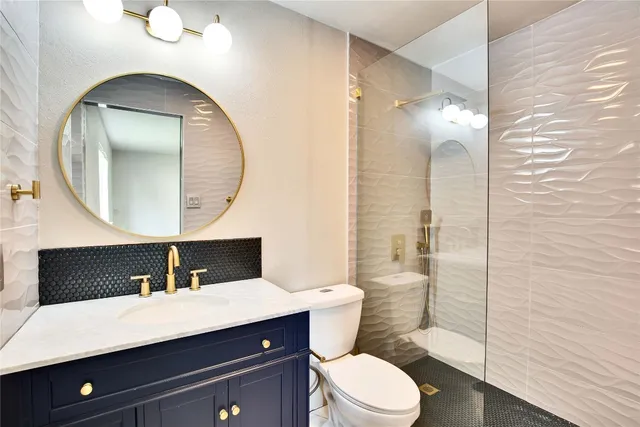 a bathroom with a sink a toilet and shower