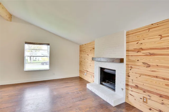 wooden floor fireplace and windows in an empty room