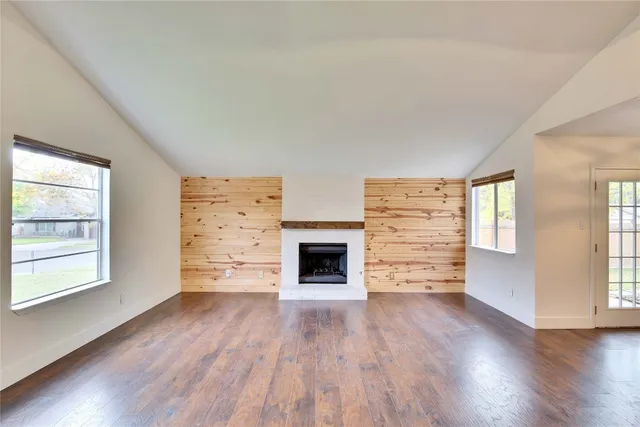 an empty room with windows and a fireplace