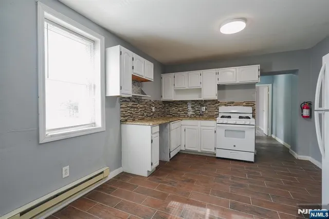 a kitchen with granite countertop white cabinets and white appliances