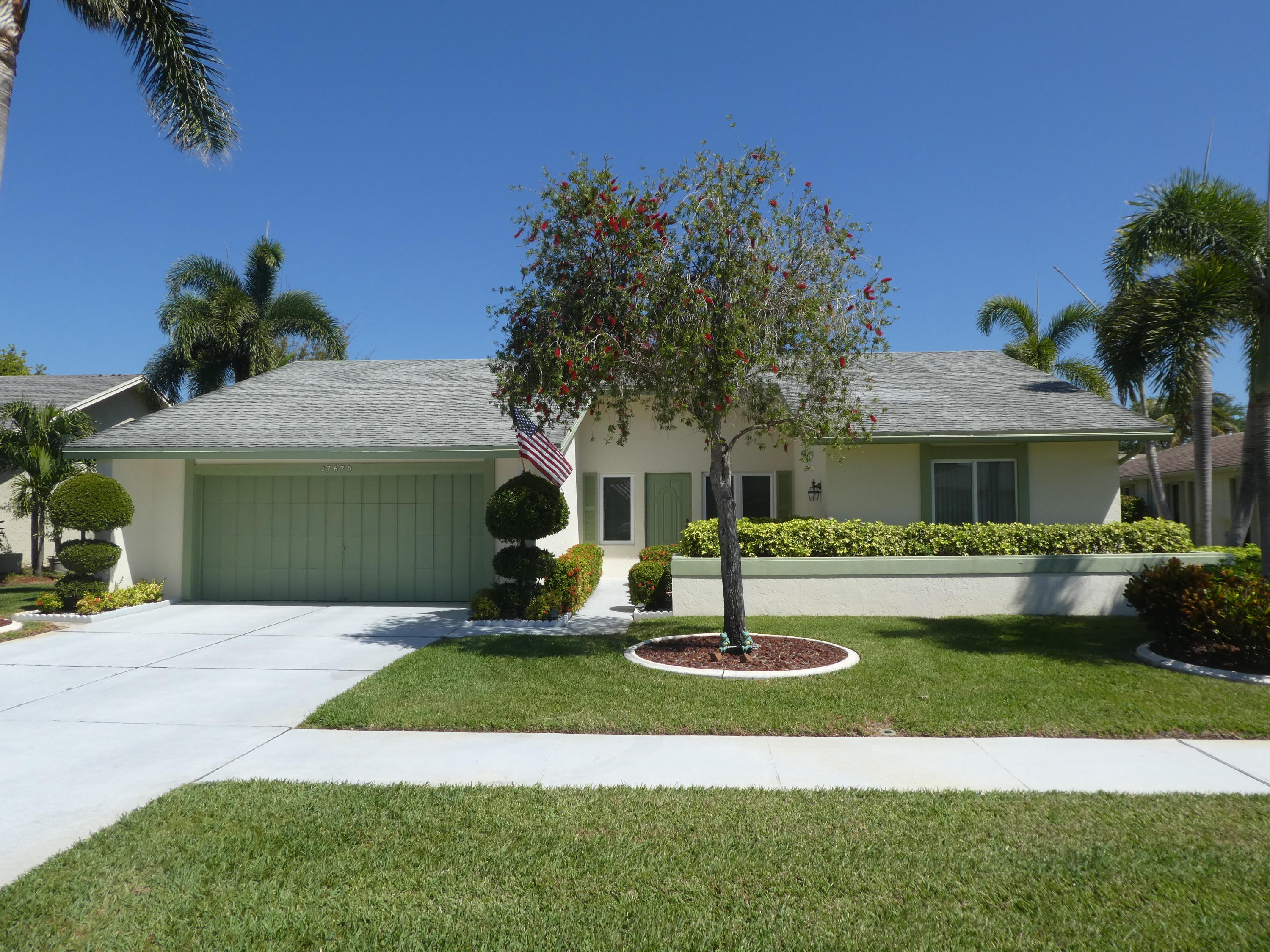 a front view of a house with a garden and trees