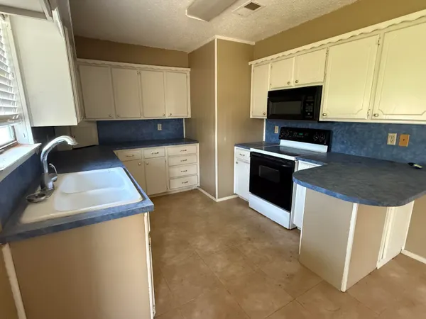 a kitchen with stainless steel appliances a stove a microwave a sink and cabinets