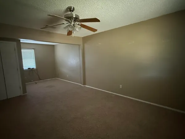 an empty room with a ceiling fan and painted walls
