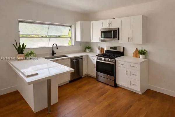 a kitchen with a stove a sink and a microwave