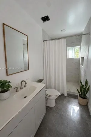 a bathroom with a toilet a sink and mirror