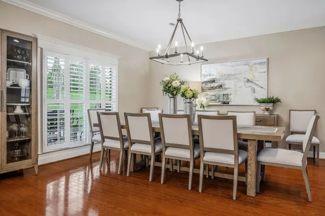 a dining room with furniture a chandelier and wooden floor