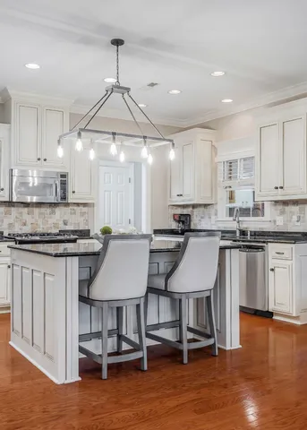 a kitchen with a sink cabinets and wooden floor