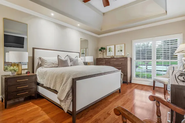 a bedroom with a bed and a flat tv screen on dresser