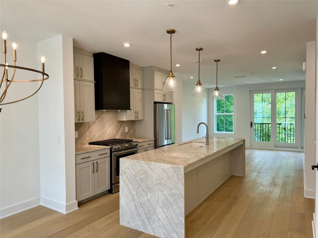 a open kitchen with stainless steel appliances granite countertop a sink a stove and a wooden floors