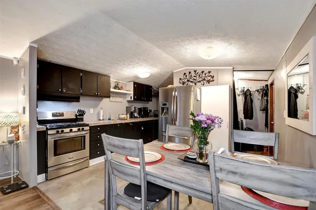 a kitchen with stainless steel appliances granite countertop a stove refrigerator sink and cabinets