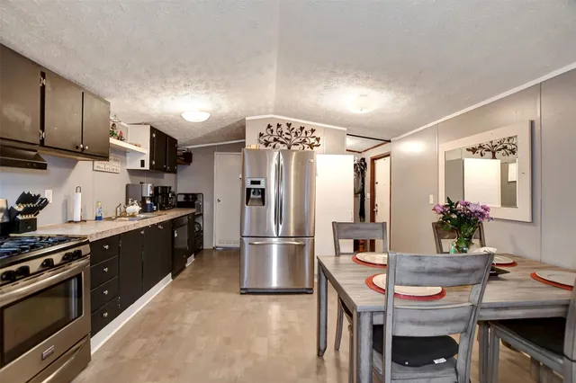 a kitchen with stainless steel appliances kitchen island granite countertop a refrigerator a stove a sink and a refrigerator