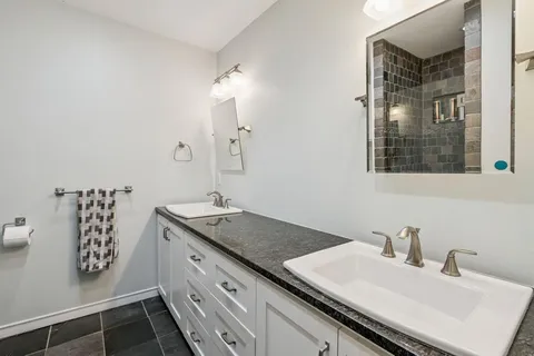 a bathroom with a granite countertop sink and a mirror