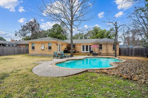 a view of a house with swimming pool and a yard