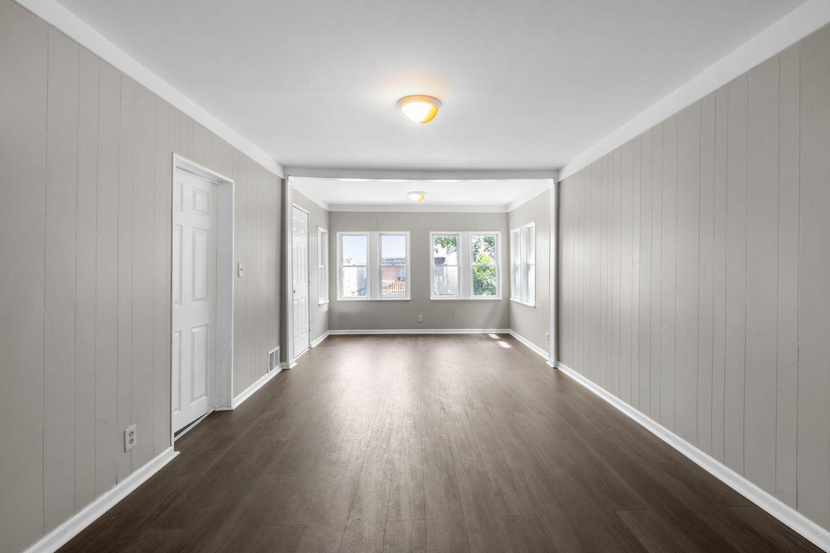 7518 South Rhodes Avenue Chicago, IL 60619 - Photo 4 of 12 an empty room with wooden floor and windows