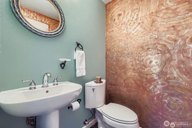 a bathroom with a toilet sink and mirror
