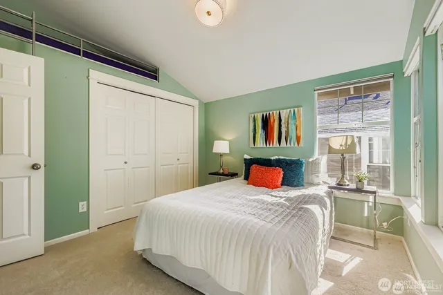 a bedroom with a bed and a painting on the wall