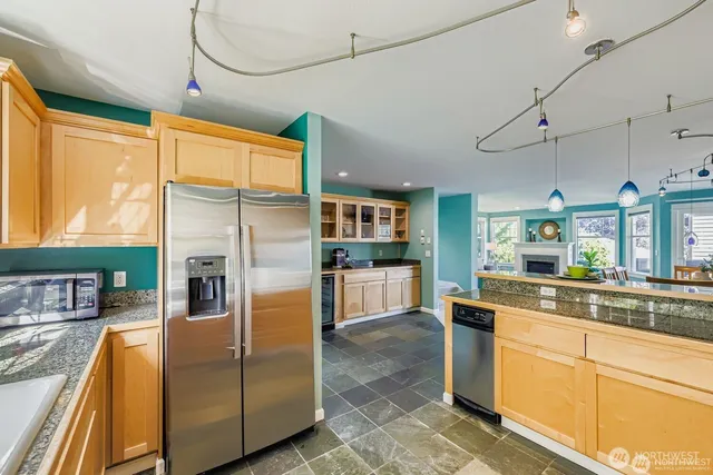 a kitchen with stainless steel appliances granite countertop a refrigerator a oven and white cabinets