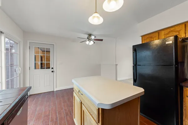 a kitchen that has a refrigerator a stove and white cabinets with wooden floor