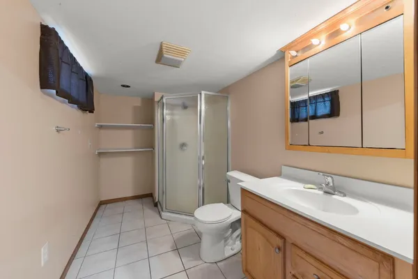 a bathroom with a toilet sink double vanity and mirror