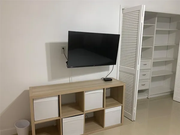 a living room with a flat screen tv and white walls