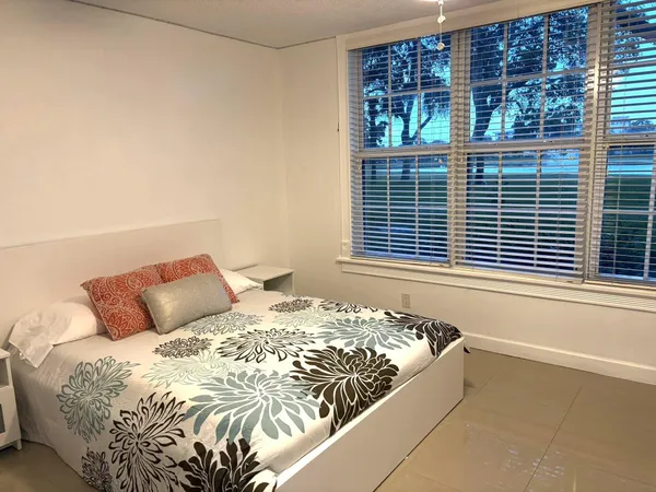 a bed sitting in a bedroom next to a window