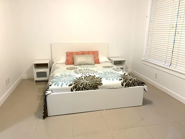 a bed sitting in a bedroom next to a window