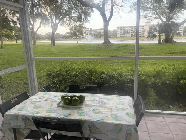 a view of a patio with table and chairs and a big yard