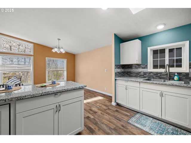 a kitchen with granite countertop a sink and a stove