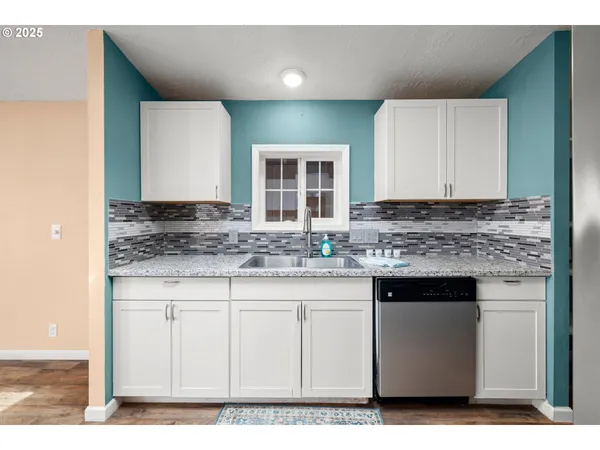 a kitchen with granite countertop a sink and cabinets